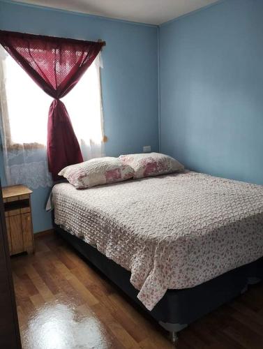 um quarto com uma cama e uma janela em Cabañas quemchi em Quemchi