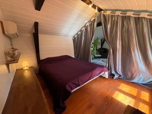a bedroom with a bed in a room with wooden floors at Charmant trois pièces à la campagne in Pouillon