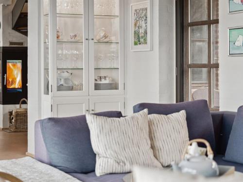 uma sala de estar com um sofá azul e um armário de vidro em Holiday Home Damiana - 600m from the sea in NW Jutland by Interhome em Blokhus