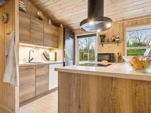 uma cozinha com armários de madeira e uma bancada em Holiday Home Alruna - all inclusive - 350m from the sea by Interhome em Brøndstrup