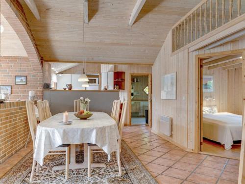 a dining room with a table and a bedroom at Holiday Home Svenger - 800m from the sea in NW Jutland by Interhome in Fjerritslev