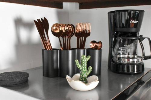 a counter with two black containers with forks and a cactus at Nomad Casa en la mejor ubicación in Hermosillo