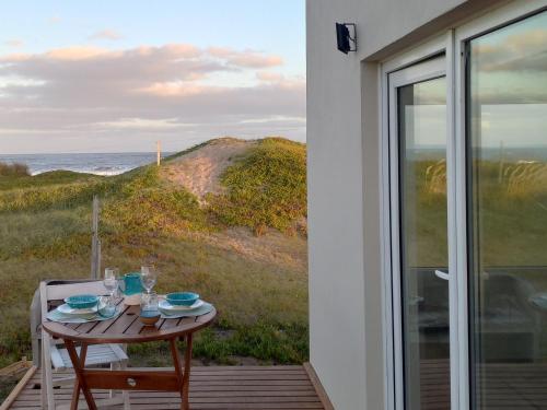 a table on a porch with a view of the ocean at La Casa de Caro Playa in Mar de Cobo