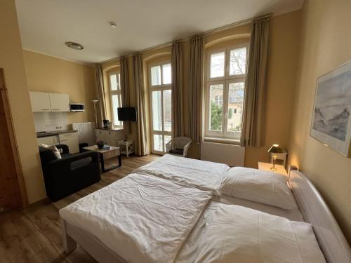 een slaapkamer met een groot wit bed en ramen bij Apartment Zinnowitzer Hof by Interhome in Zinnowitz