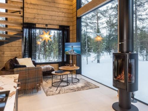 a living room with a fireplace in a log cabin at Holiday Home Levin kuiskaus by Interhome in Sirkka