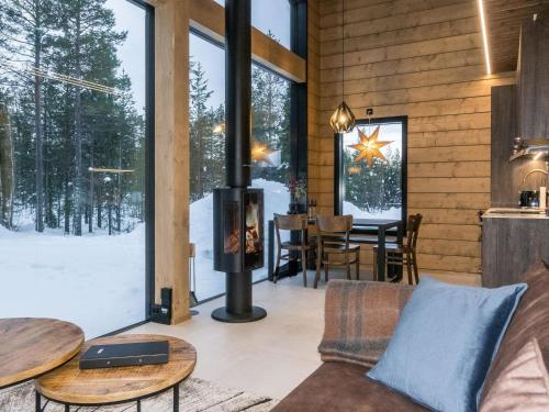a living room with a fireplace in a log cabin at Holiday Home Levin kuiskaus by Interhome in Sirkka