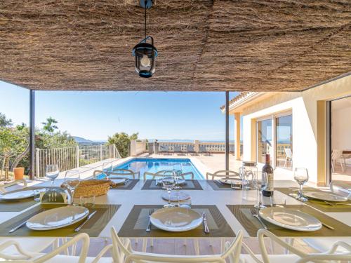 - une salle à manger avec une table, des chaises et une piscine dans l'établissement Holiday Home Belle vue by Interhome, à Palau-Saverdera