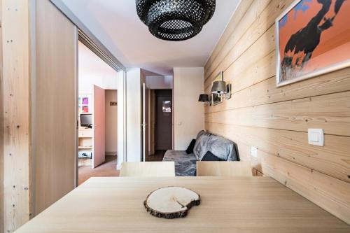 Cette chambre est dotée d'un mur en bois avec une table et des chaises. dans l'établissement Résidence Plagne Lauze - maeva Home - Studio 4 Personnes - Prestige MAE-2634, à Mâcot La Plagne