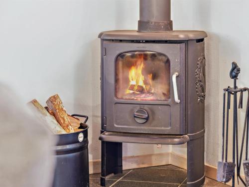 a wood stove with a fire in a room at Holiday Home Ani - 600m from the sea in NW Jutland by Interhome in Torsted