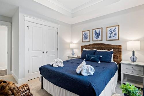 a bedroom with a blue bed with towels on it at Luxury Getaway! Brand New 4BD! Near Coligny Beach in Hilton Head Island