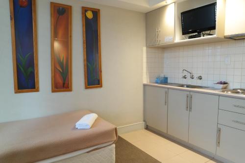 a small kitchen with white cabinets and a sink at Parkville Place Serviced Apartments in Melbourne
