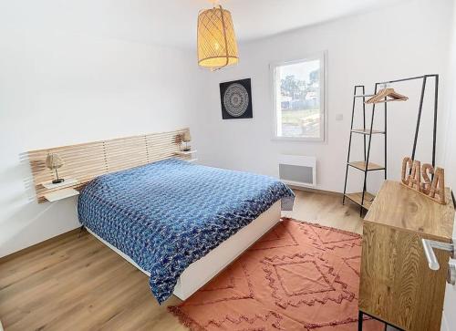 une chambre avec un lit avec une couette bleue dans l'établissement Villa 6 personnes proche mer et forêt, à Saint-Jean-de-Monts