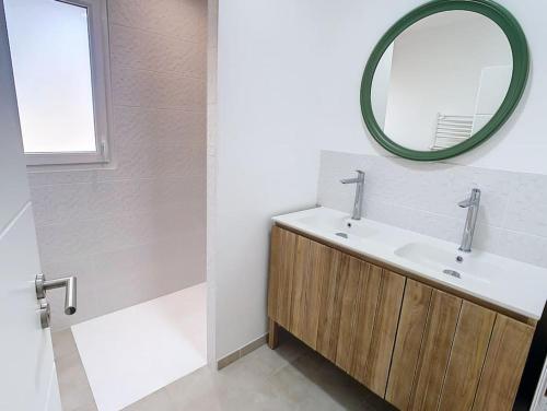 une salle de bain avec un lavabo et un miroir dans l'établissement Villa 6 personnes proche mer et forêt, à Saint-Jean-de-Monts