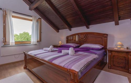 a bedroom with a large wooden bed with purple pillows at House Soul in Oklaj