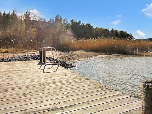 un banc assis sur un quai à côté d'une masse d'eau dans l'établissement Holiday Home Vikdal by Interhome, à Karuna