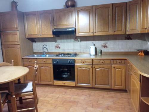 a kitchen with wooden cabinets and a stove top oven at Lake & bike Mergozzo in Mergozzo