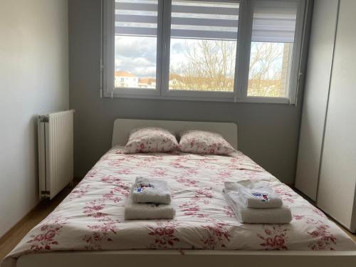 a bedroom with a bed with two pillows and a window at Mickey House 6 pers 10 Min Disney & 30Min Paris in Bussy-Saint-Georges