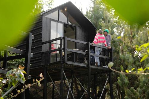 two people standing on the balcony of a tiny house at Tiny House La Silleta in Medellín