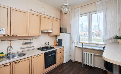 a kitchen with wooden cabinets and a sink and a window at River view Cathedral Apartment in Vilnius