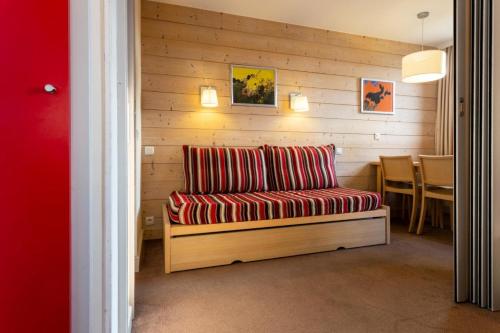 - un canapé rouge dans une chambre avec une table dans l'établissement Résidence Plagne Lauze - maeva Home - Studio 4 personnes - Sélection MAE-4094, à Mâcot La Plagne