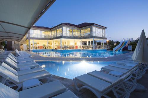 a swimming pool with lounge chairs and a house at Sun Club Side Hotel - All inclusive in Side