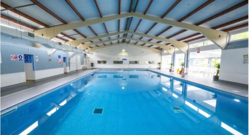 uma grande piscina interior com água azul em DELUXE COASTAL Chalet near the beach with Swimming pool in Kingsdown No 53 em Kingsdown