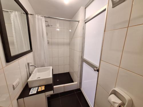 a small bathroom with a sink and a shower at Mapi Gardens Machupicchu B&B in Machu Picchu