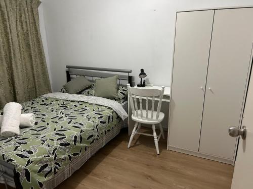 um quarto com uma cama, uma cadeira e uma secretária em double room share bathroom and kitchen em Perth