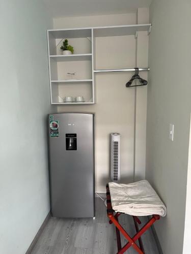 a small room with a refrigerator and a stool at Constanza Lofts Executives en Zapopan Jalisco in Guadalajara