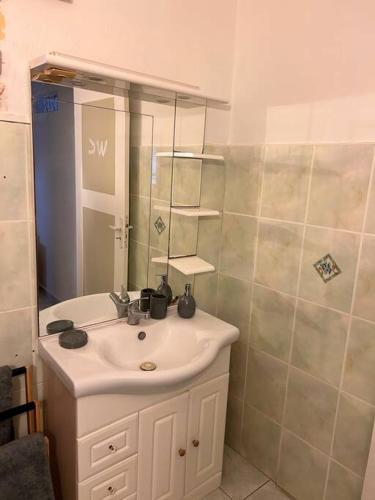a bathroom with a white sink and a mirror at La Maison Cocktail in Émilien