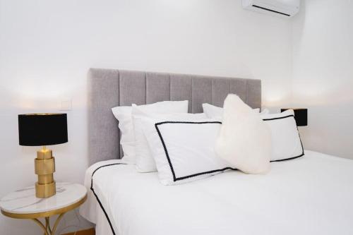 a bedroom with a white bed with white pillows at Saw Paradise in Praia T2 in Praia