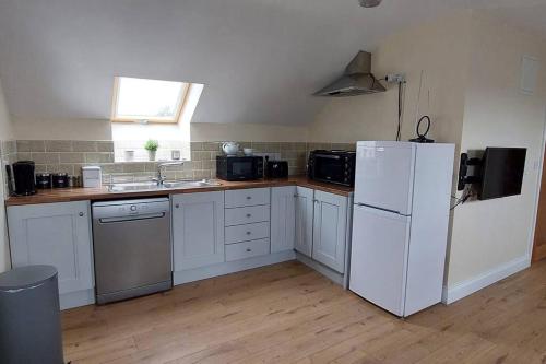 a kitchen with white appliances and a white refrigerator at Modern Countryside apartment Killmallock Lodge in Enniscorthy