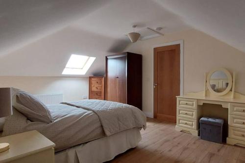 um quarto com uma cama, uma cómoda e um espelho em Modern Countryside apartment Killmallock Lodge em Enniscorthy