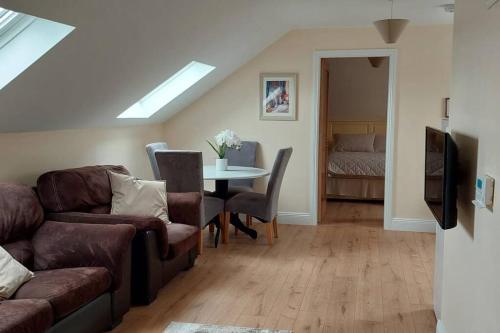 a living room with a couch and a table at Modern Countryside apartment Killmallock Lodge in Enniscorthy