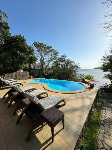 uma piscina com espreguiçadeiras e o oceano em Nativo em Santa Catalina