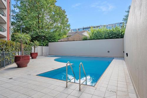 een zwembad in een achtertuin met een wit hek bij CityStyle Apartments in Canberra