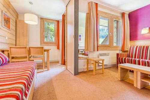 a room with a bed and a table and chairs at Résidence Plagne Lauze - maeva Home - Studio 4 Personnes - Sélection MAE-4354 in Mâcot La Plagne