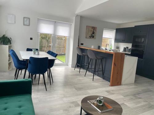 a kitchen and living room with a table and chairs at Brand New Big House with garden and free parking in Brentford