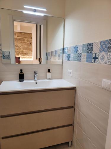 uma casa de banho com um lavatório e um espelho em Paradiso di Maiorca em Alghero