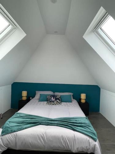 a bedroom with a large bed in a attic at Brand New Big House with garden and free parking in Brentford
