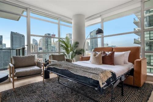 1 dormitorio con 1 cama, 1 silla y ventanas en Manhattan, en Calgary