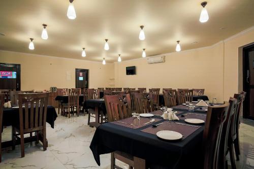 un comedor con mesas, sillas y luces en Collection O Hotel Sincro en Madgaon