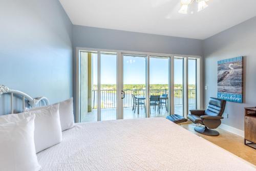 a bedroom with a large bed and a balcony at Sailmakers Place 703 in Perdido Key