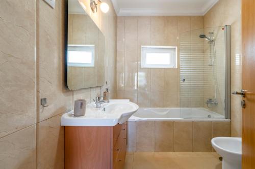 a bathroom with a sink and a bath tub at Villa Laranja-Limao - NEW in Azeitao