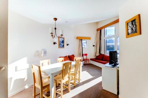 une salle à manger et un salon avec une table et des chaises blanches dans l'établissement Résidence Quartier Falaise - maeva Home - Appartement 2 Pièces 7 Personnes - Sélection MAE-0584, à Avoriaz