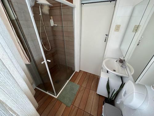 a bathroom with a shower and a toilet and a sink at Quarto Econômico com Ar Cond. e Smart Tv Netflix in Itajaí