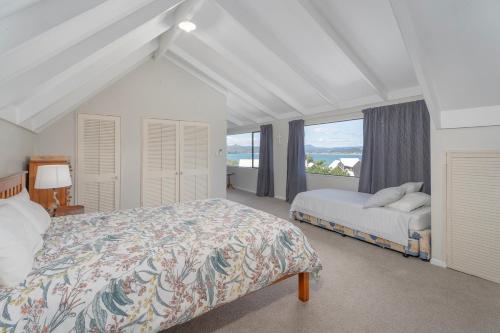 een slaapkamer met een bed en een groot raam bij Perfect Picture on Haddon in Whitianga
