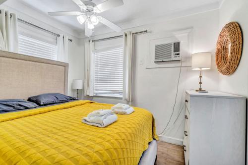 a bedroom with a yellow bed and a ceiling fan at Charming Cottage 1BR, Pool, Victoria Park in Fort Lauderdale