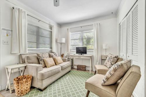 a living room with a couch and a desk with a computer at Charming Cottage 1BR, Pool, Victoria Park in Fort Lauderdale