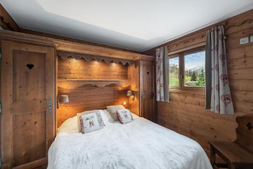 a bedroom with a bed with a wooden wall at Résidence Ferm A - 3 Pièces pour 4 Personnes 204 in Les Allues